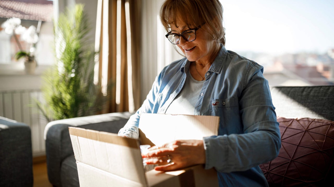 Excited senior woman unpacking online order