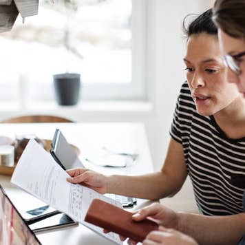 couple discussing over financial bills while using laptop at table