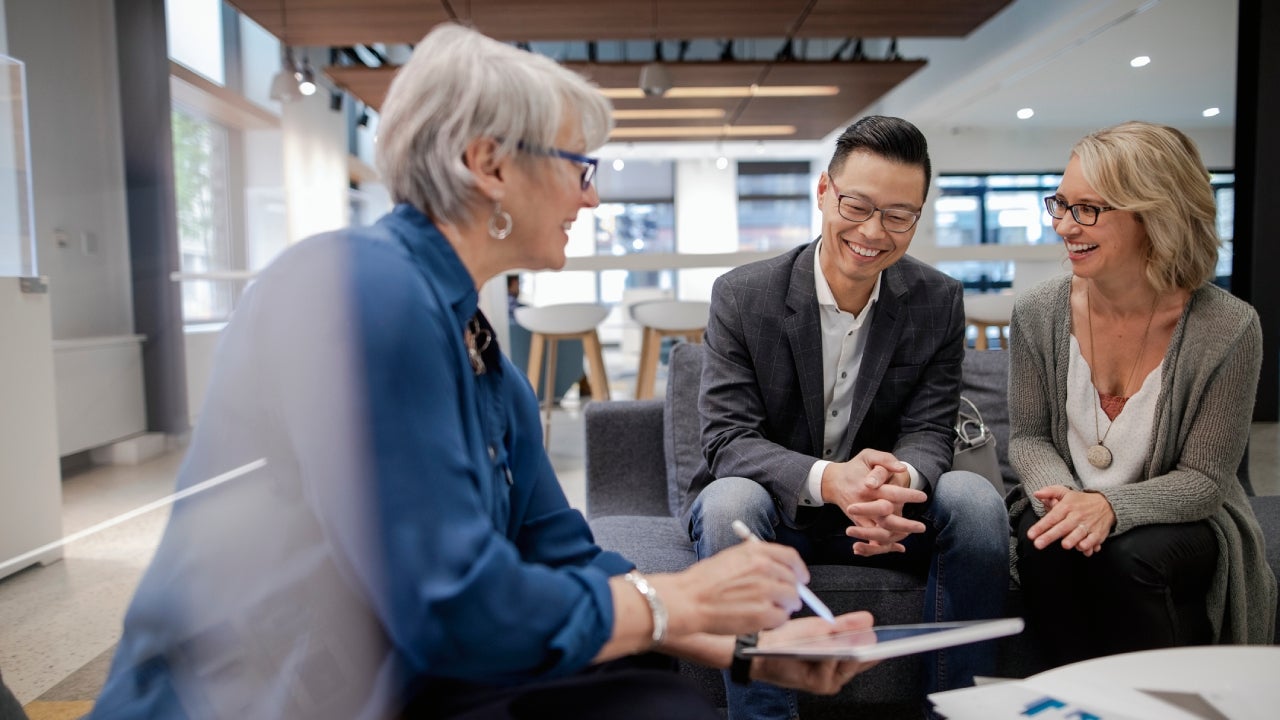 Loan manager meeting with happy couple in bank branch