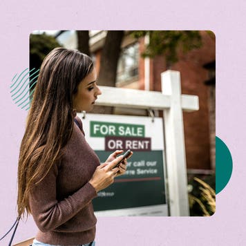 Woman on cell phone standing in front of a home for sale sign