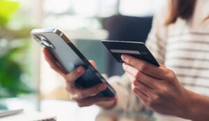 Woman holding credit card and mobile phone