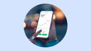 Close up of hands holding a phone that shows a financial chart.